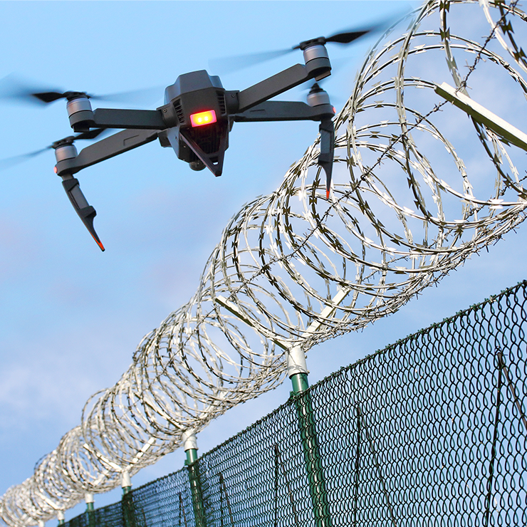 Drone flying over barb wire fence